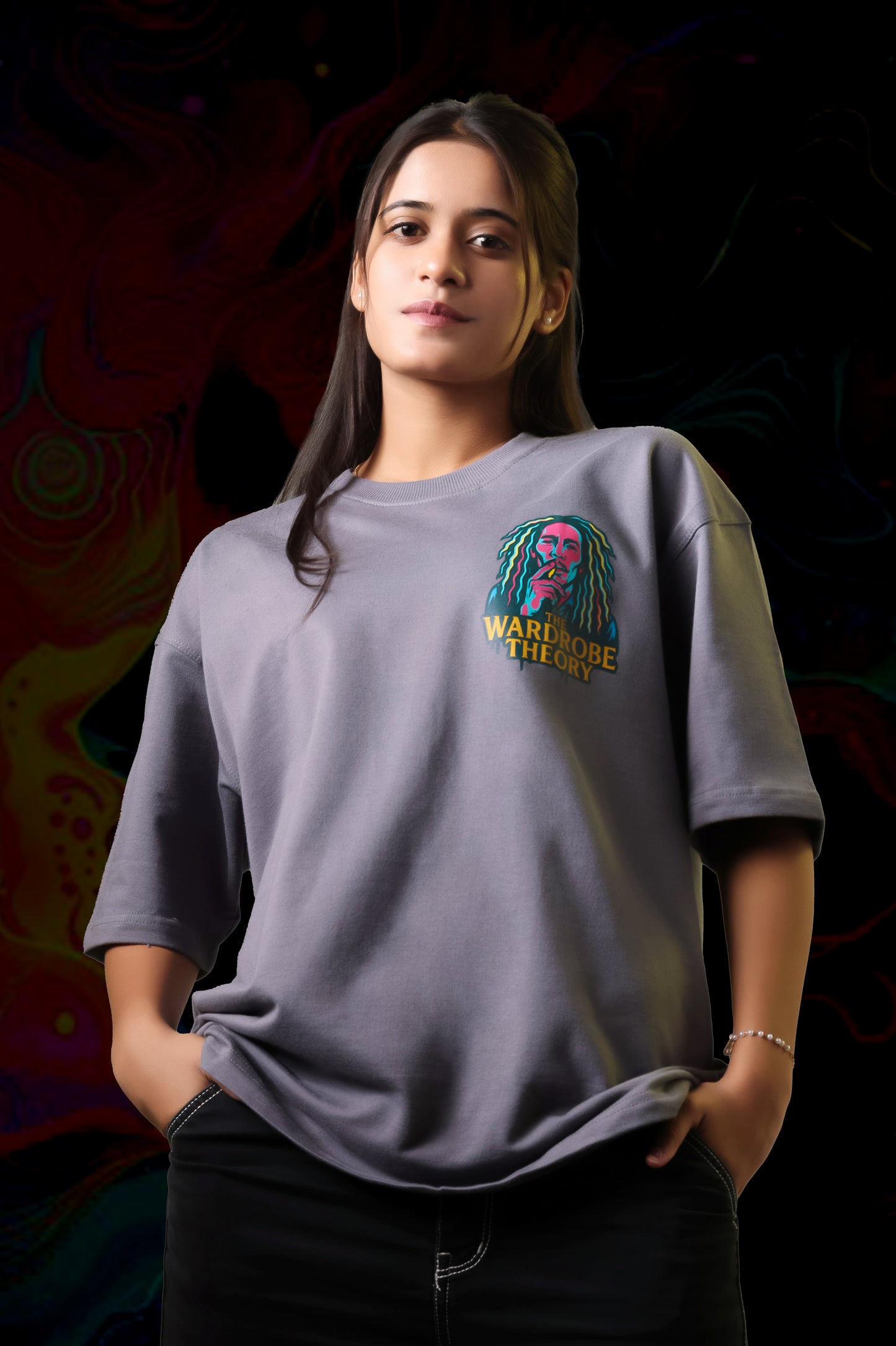 Person wearing a gray t-shirt with a colorful graphic design on a dark background